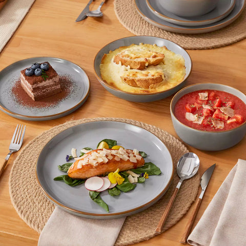 Rustic grey speckled stoneware dinnerware set with lipped-edge plates and bowls arranged on a sunlit modern dining table-vancasso