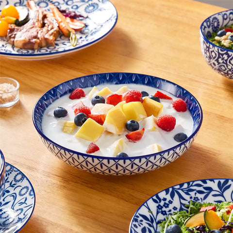 Selene 16-piece porcelain set with indigo floral and geometric patterns on plates - bowls - and mugs displayed on a dining table