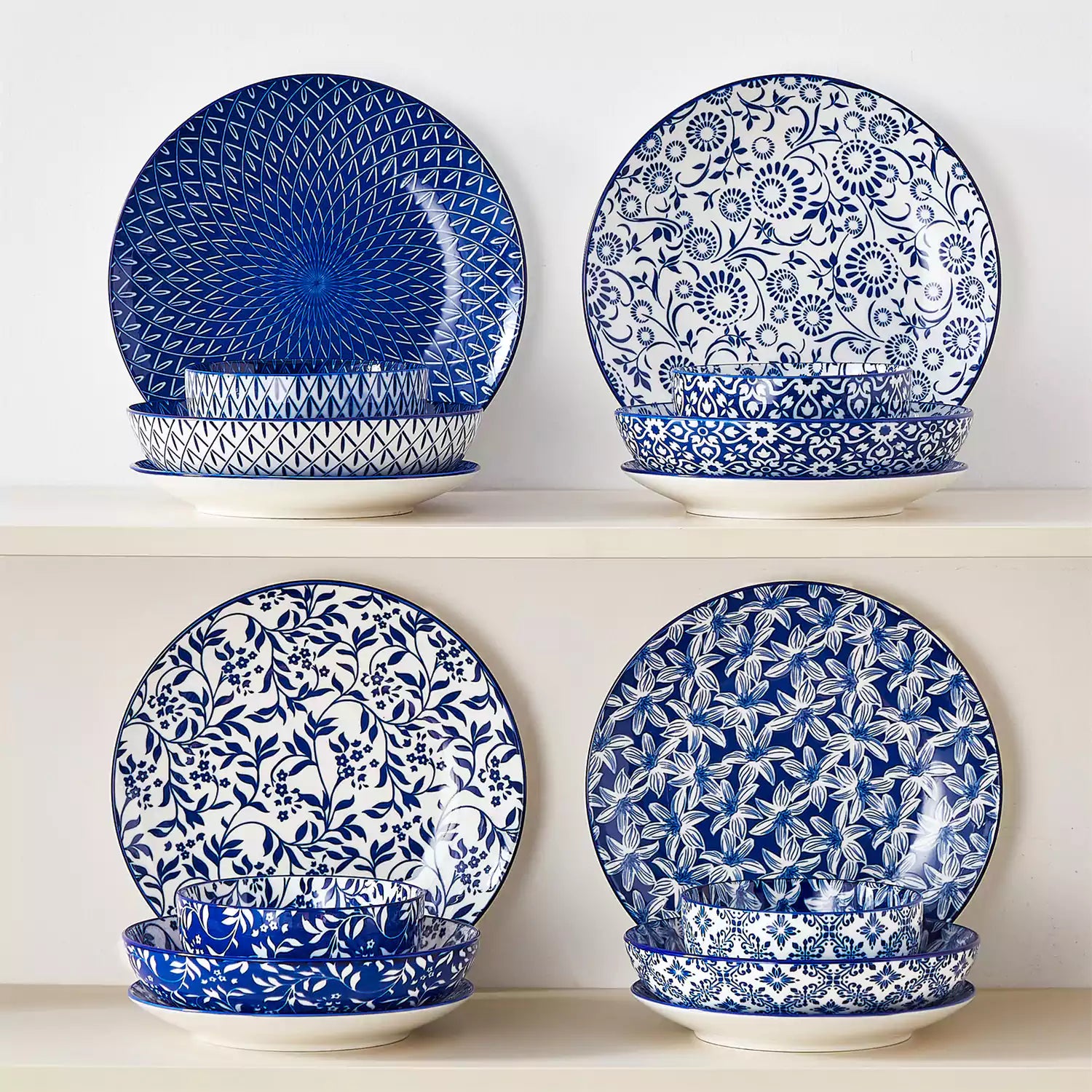 Selene 16-piece porcelain set with indigo floral and geometric patterns on plates - bowls - and mugs displayed on a dining table