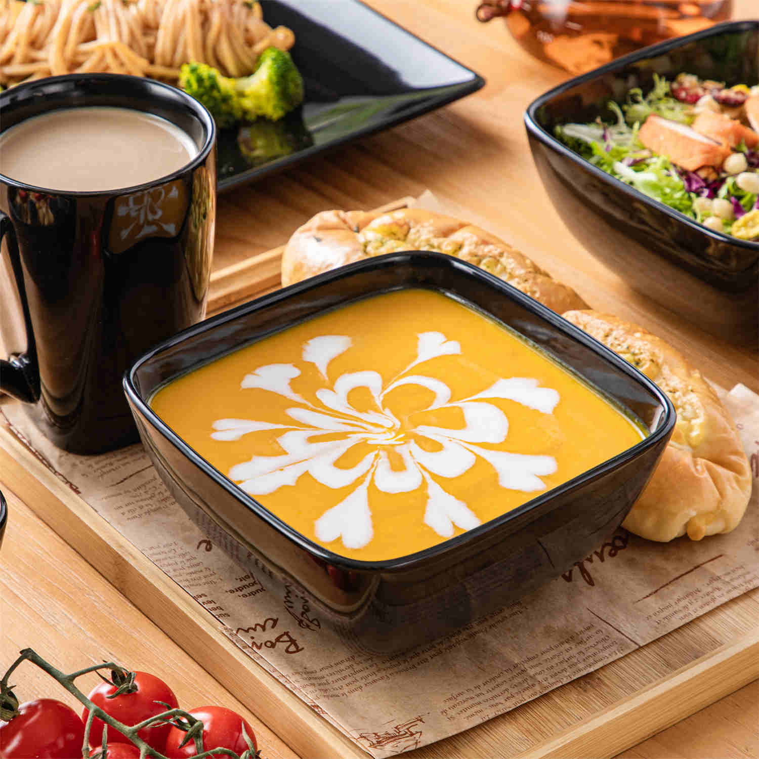 A glossy black 24-piece stoneware dinnerware set from the Soho collection - featuring a sleek square design with plates and mugs for 6 people-vancasso
