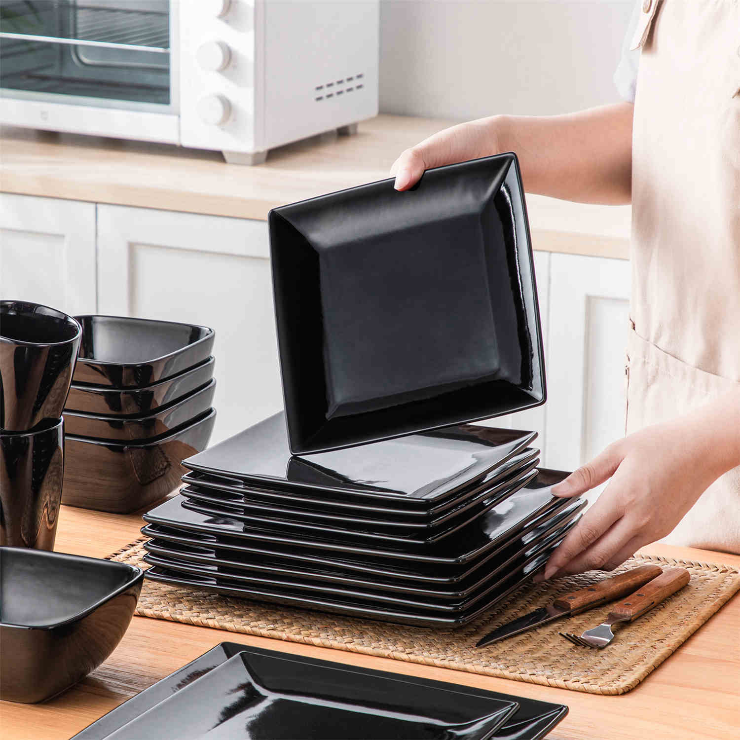 A glossy black 24-piece stoneware dinnerware set from the Soho collection - featuring a sleek square design with plates and mugs for 6 people-vancasso