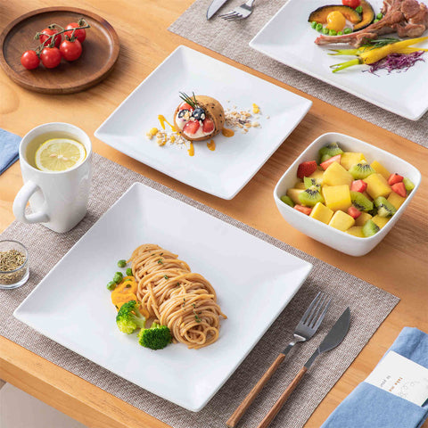 A glossy white 24-piece stoneware dinnerware set from the Soho collection - featuring a sleek square design with plates and mugs for 6 people-vancasso