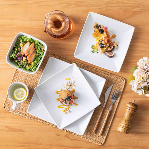 A glossy white 24-piece stoneware dinnerware set from the Soho collection - featuring a sleek square design with plates and mugs for 6 people-vancasso