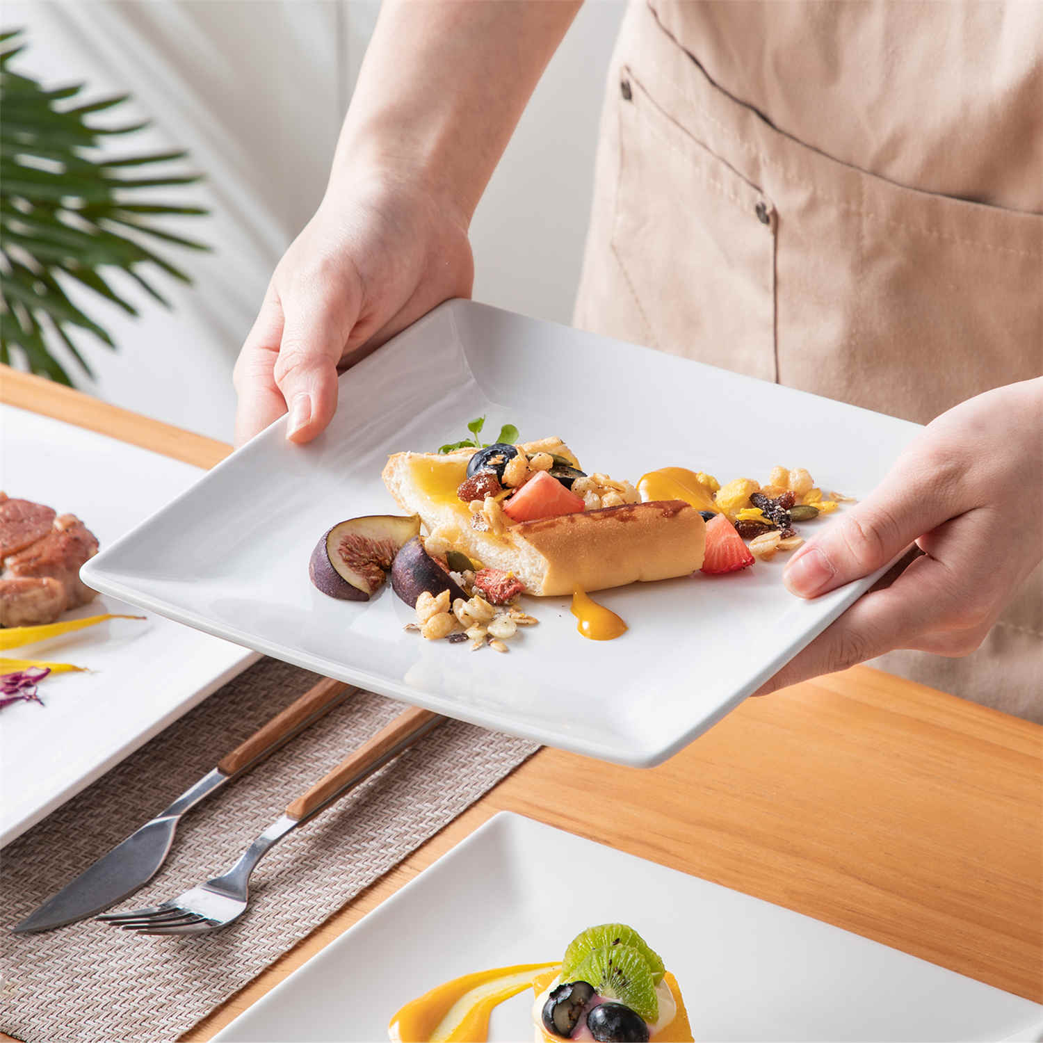 A glossy white 24-piece stoneware dinnerware set from the Soho collection - featuring a sleek square design with plates and mugs for 6 people-vancasso
