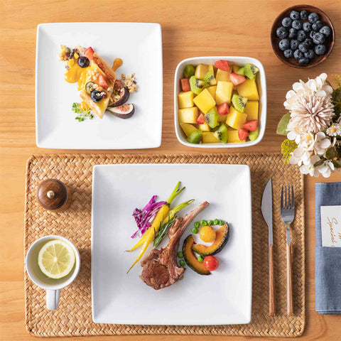 A glossy white 24-piece stoneware dinnerware set from the Soho collection - featuring a sleek square design with plates and mugs for 6 people-vancasso