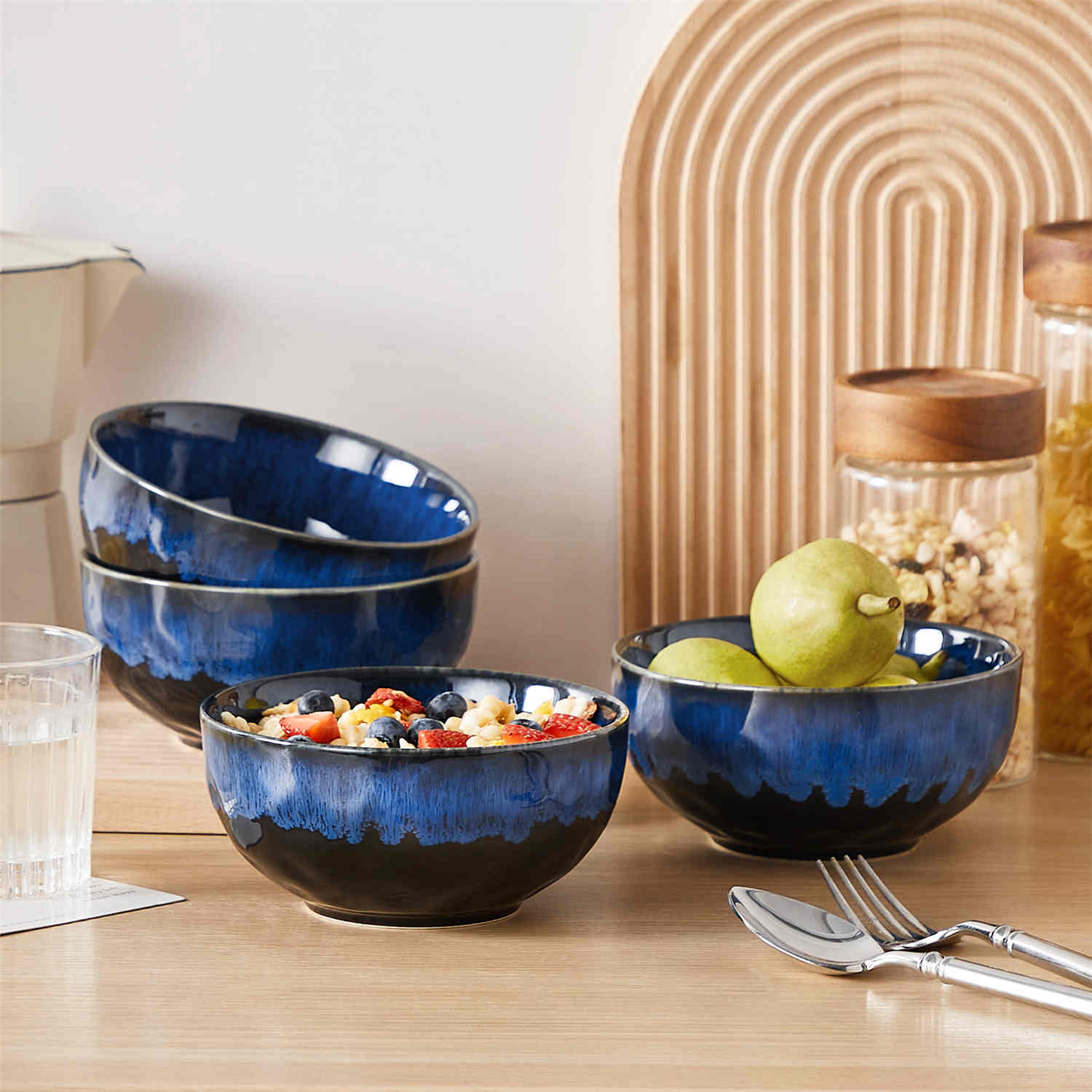 Starry reactive glaze cereal bowls in blue on a rustic wooden table - filled with creamy soup - pasta - and fresh fruit salad for a cozy - celestial dining vibe