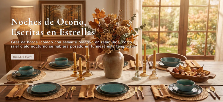 Una mesa decorada con motivos otoñales en una estancia cálida y luminosa. La mesa está vestida con cuencos de cerámica color verde azulado, cubertería dorada, manteles individuales tejidos y un gran jarrón central lleno de follaje otoñal.