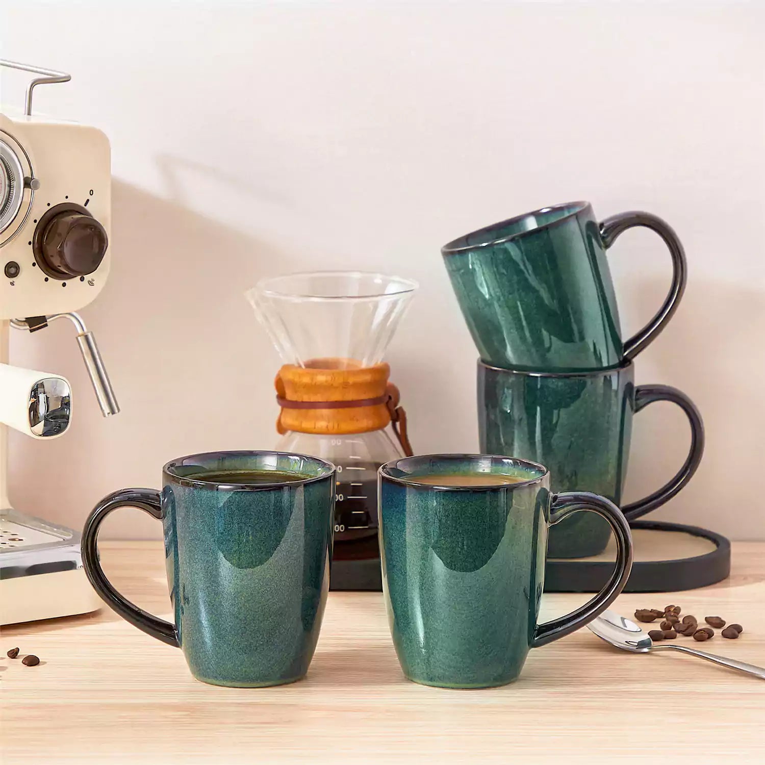 Set of 4 Starry 16oz stoneware mugs in green with reactive glaze finish styled on a marble countertop with fresh coffee
