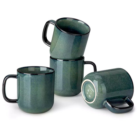 Four starry green 16oz stoneware mugs with latte art on wooden table beside coffee brewing equipment