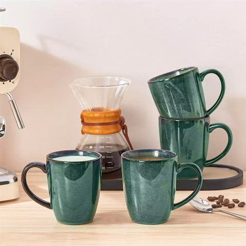 Green Starry 12oz stoneware mugs set of 4 with reactive glaze finish on a kitchen counter with coffee milk and fresh bread