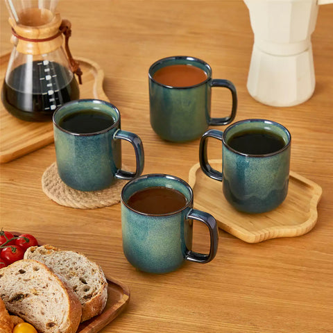 Starry teal 12oz stoneware mugs set of 4 with coffee on wooden table next to coffee maker and fresh bread cozy breakfast scene