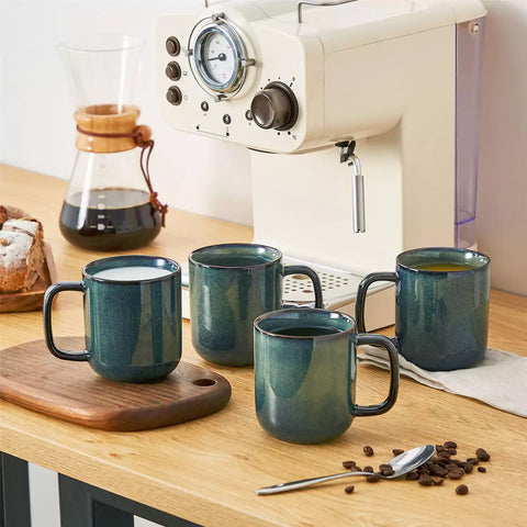 Starry teal 12oz stoneware mugs set of 4 with coffee on wooden table next to coffee maker and fresh bread cozy breakfast scene