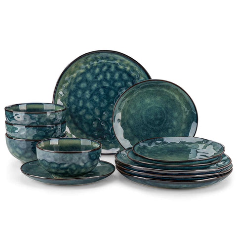 Starry 12-piece stoneware dinnerware set in green on a light wooden table - styled with lamb chops - pastries - coffee pot - and lemon water for a cozy farmhouse breakfast scene