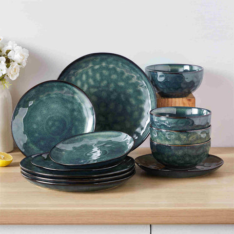 Starry 12-piece stoneware dinnerware set in green on a light wooden table - styled with lamb chops - pastries - coffee pot - and lemon water for a cozy farmhouse breakfast scene