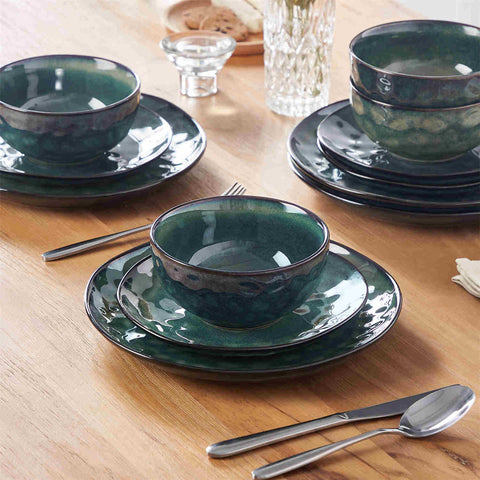 Starry 12-piece stoneware dinnerware set in green on a light wooden table - styled with lamb chops - pastries - coffee pot - and lemon water for a cozy farmhouse breakfast scene