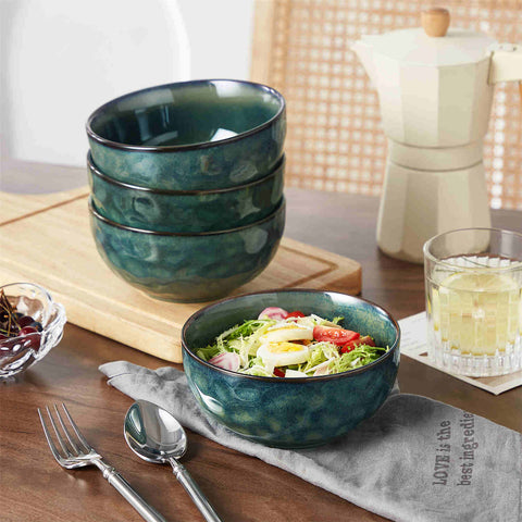 Starry reactive glaze cereal bowls in teal green on a rustic wooden table - filled with creamy soup - pasta - and fresh fruit salad for a cozy - celestial dining vibe