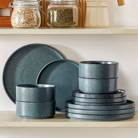 Blue reactive glaze stoneware dinner plates styled with food on rustic wood table with woven placemats modern minimalist tableware set