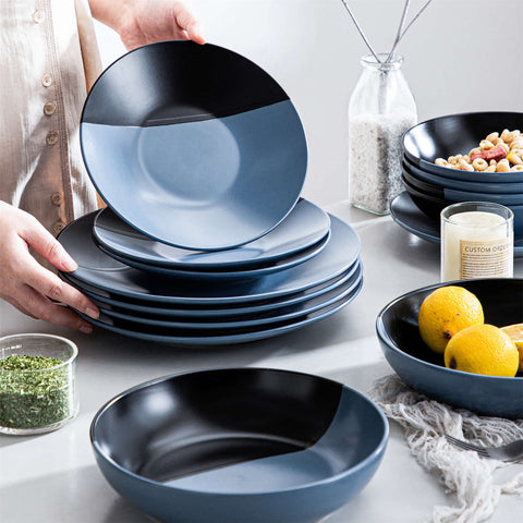 Accel 16-piece blue and black two-tone semi-matte dinnerware set with stacked plates and bowls on a dining table
